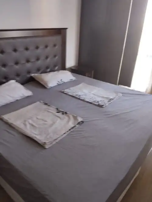 Comfortable bedroom with neatly made bed and soft pillows in a stylish apartment.