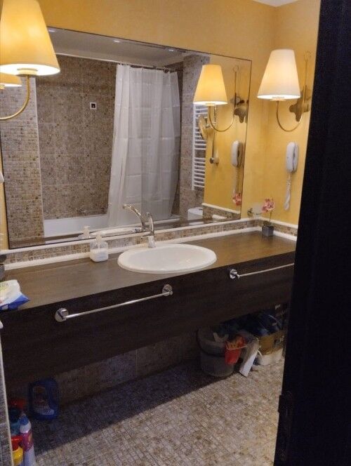Bathroom with sink, mirror, and lighting fixtures in a hotel room at Sunny Beach.