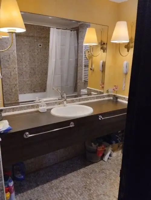 Bathroom with sink, mirror, and lighting fixtures in a hotel room at Sunny Beach.