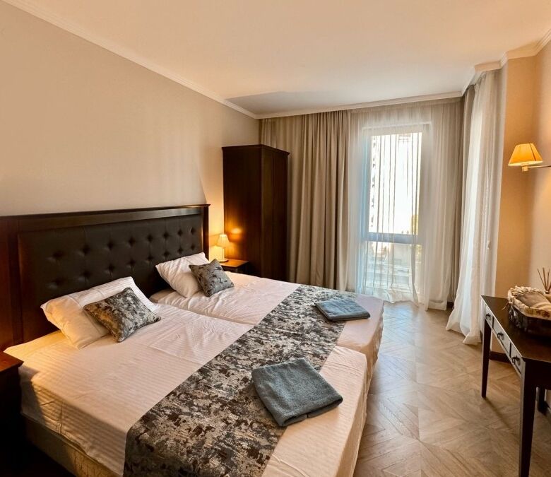 Cozy bedroom with pool view in Sunny Beach apartment, perfect for relaxing stays.