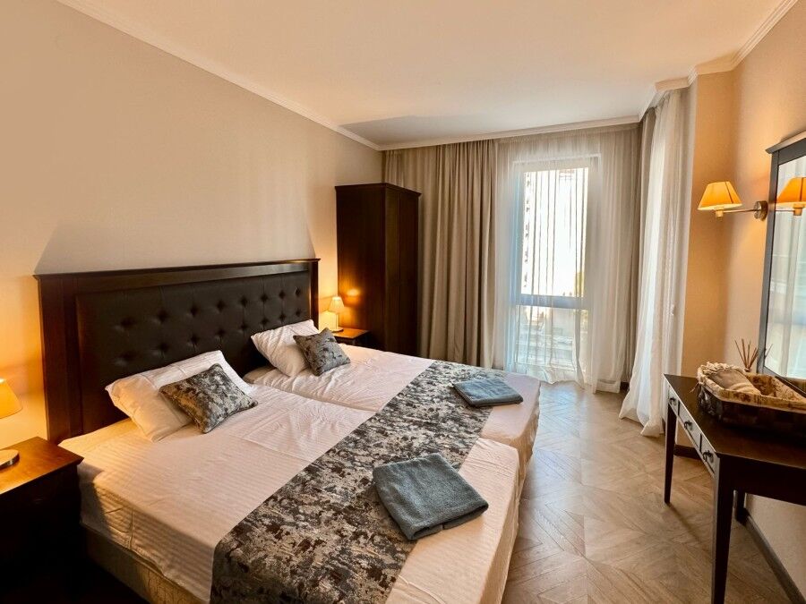 Cozy bedroom with pool view in Sunny Beach apartment, perfect for relaxing stays.