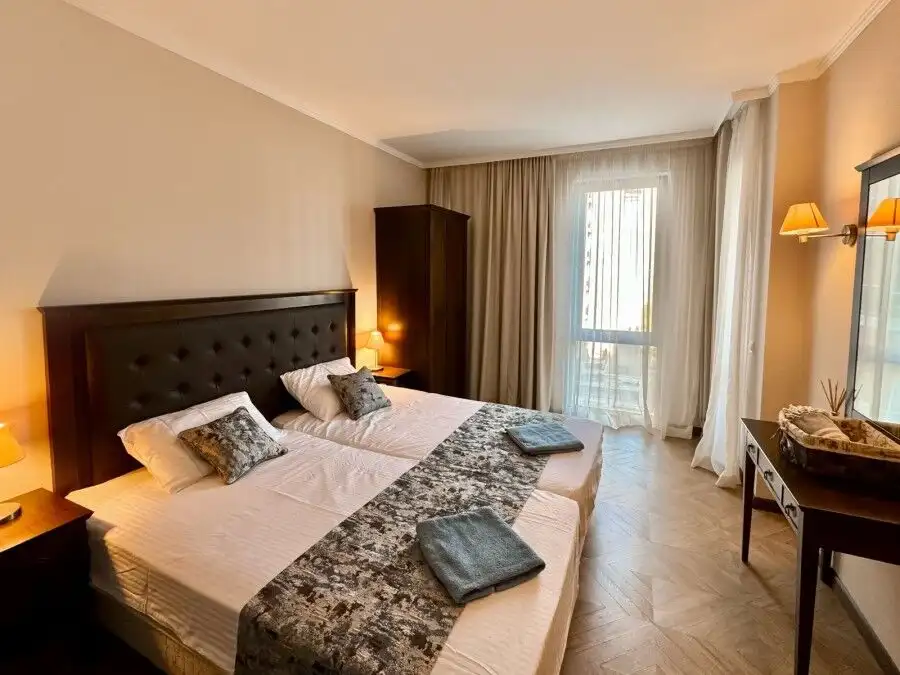 Cozy bedroom with pool view in Sunny Beach apartment, perfect for relaxing stays.
