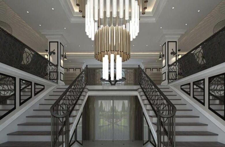 Luxurious interior of a hotel lobby featuring a double staircase and stylish lighting.