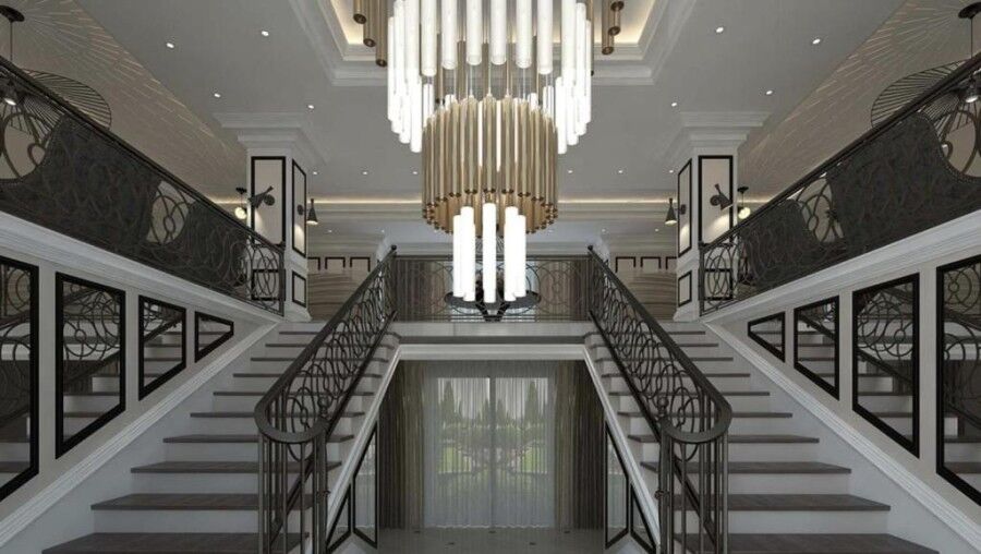 Luxurious interior of a hotel lobby featuring a double staircase and stylish lighting.