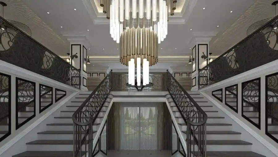 Luxurious interior of a hotel lobby featuring a double staircase and stylish lighting.