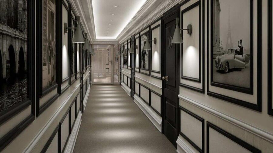 Bright hotel hallway featuring stylish black and white wall panels and soft lighting.
