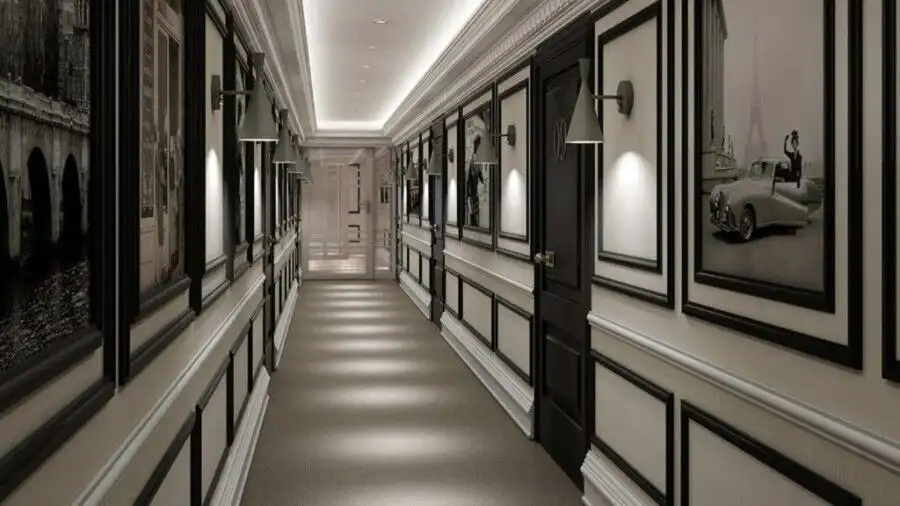 Bright hotel hallway featuring stylish black and white wall panels and soft lighting.