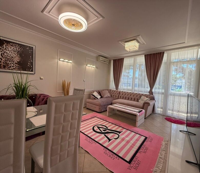 Bright living room with modern furnishings and large windows overlooking the area.