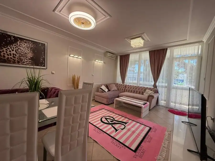 Bright living room with modern furnishings and large windows overlooking the area.