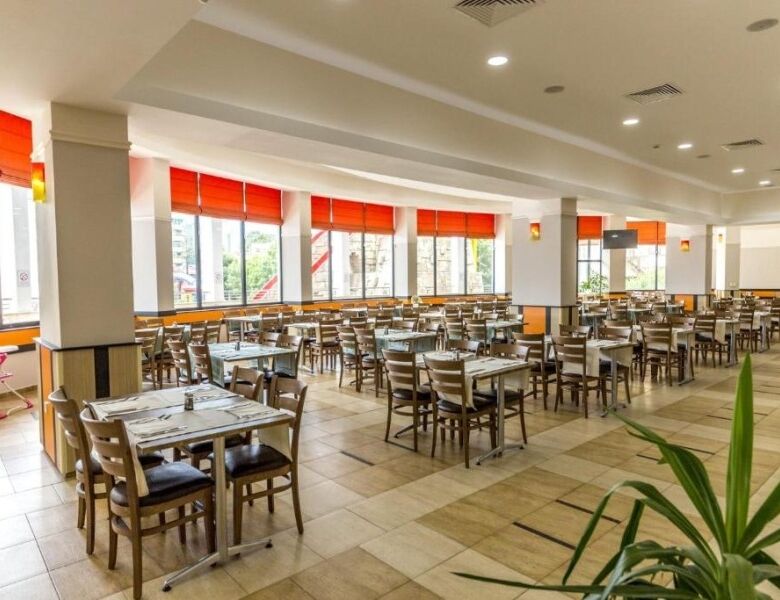 Spacious restaurant with large windows, orange blinds, and contemporary decor, perfect for dining in.