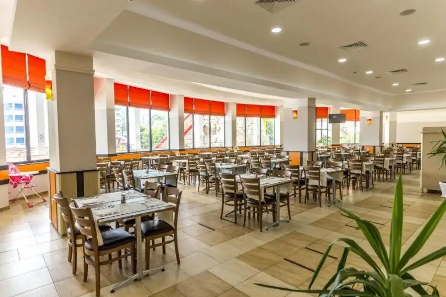 Spacious restaurant with large windows, orange blinds, and contemporary decor, perfect for dining in.