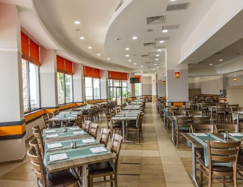 Spacious dining area in a contemporary restaurant with ample seating and natural light.