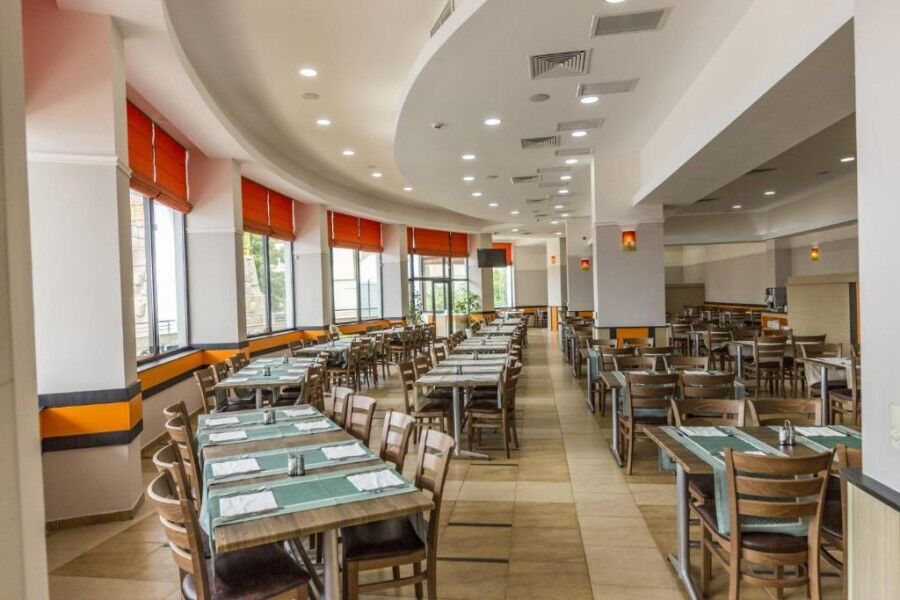 Spacious dining area in a contemporary restaurant with ample seating and natural light.