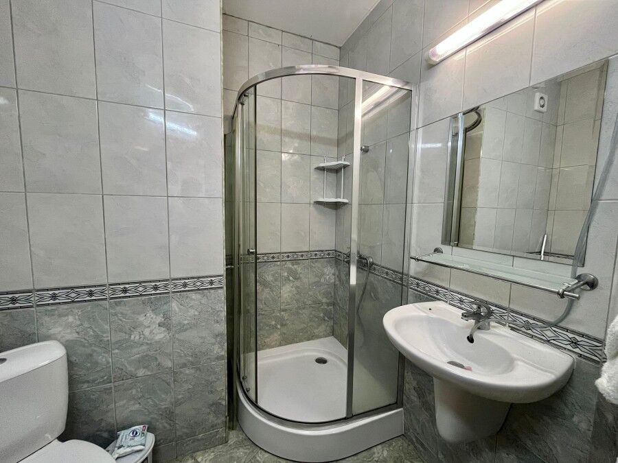 Spacious Studio in Karolina Spa Complex Interior view of a compact bathroom with shower, sink, and toilet in Karolina spa complex.