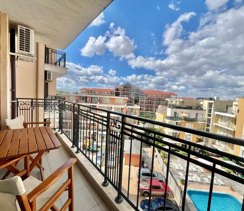 Bright balcony view of Sunny Beach with cityscape and pool.