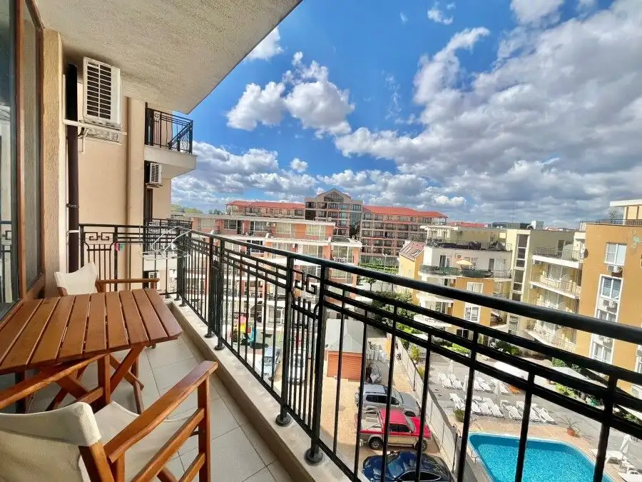 Bright balcony view of Sunny Beach with cityscape and pool.