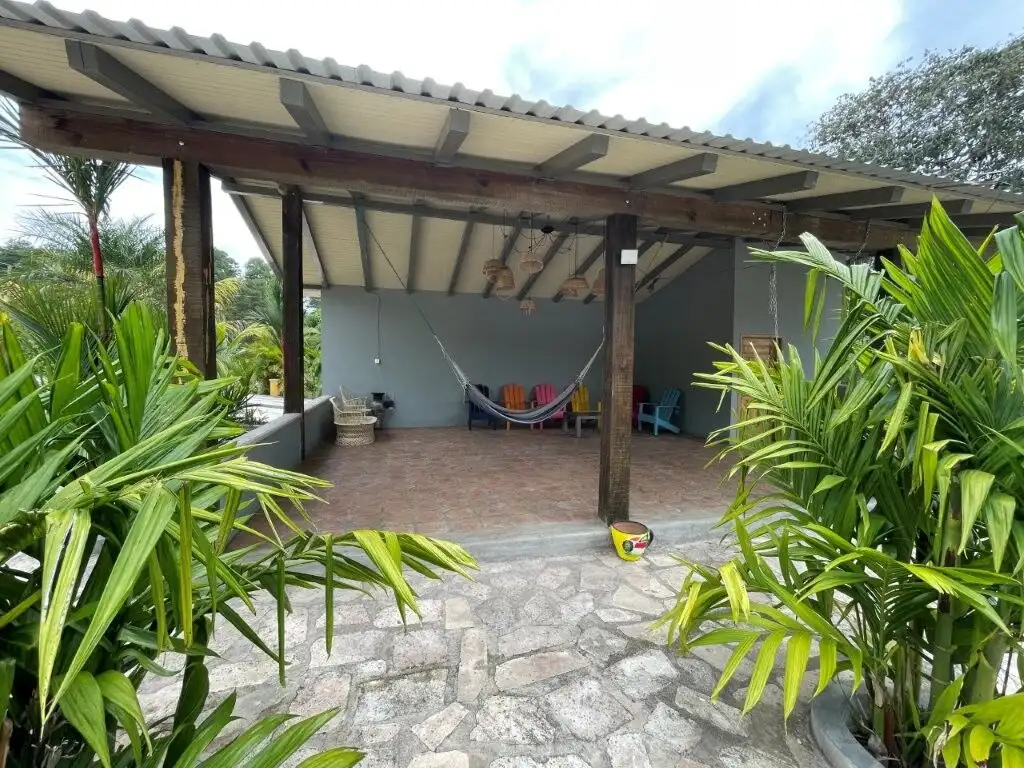 Cozy outdoor patio with hammock and seating in lush mountain setting.