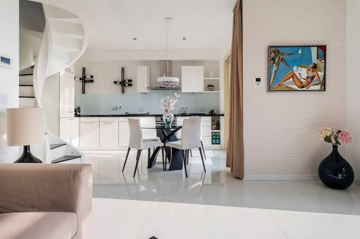 Elegant interior of a modern duplex apartment with open-plan living and dining area.
