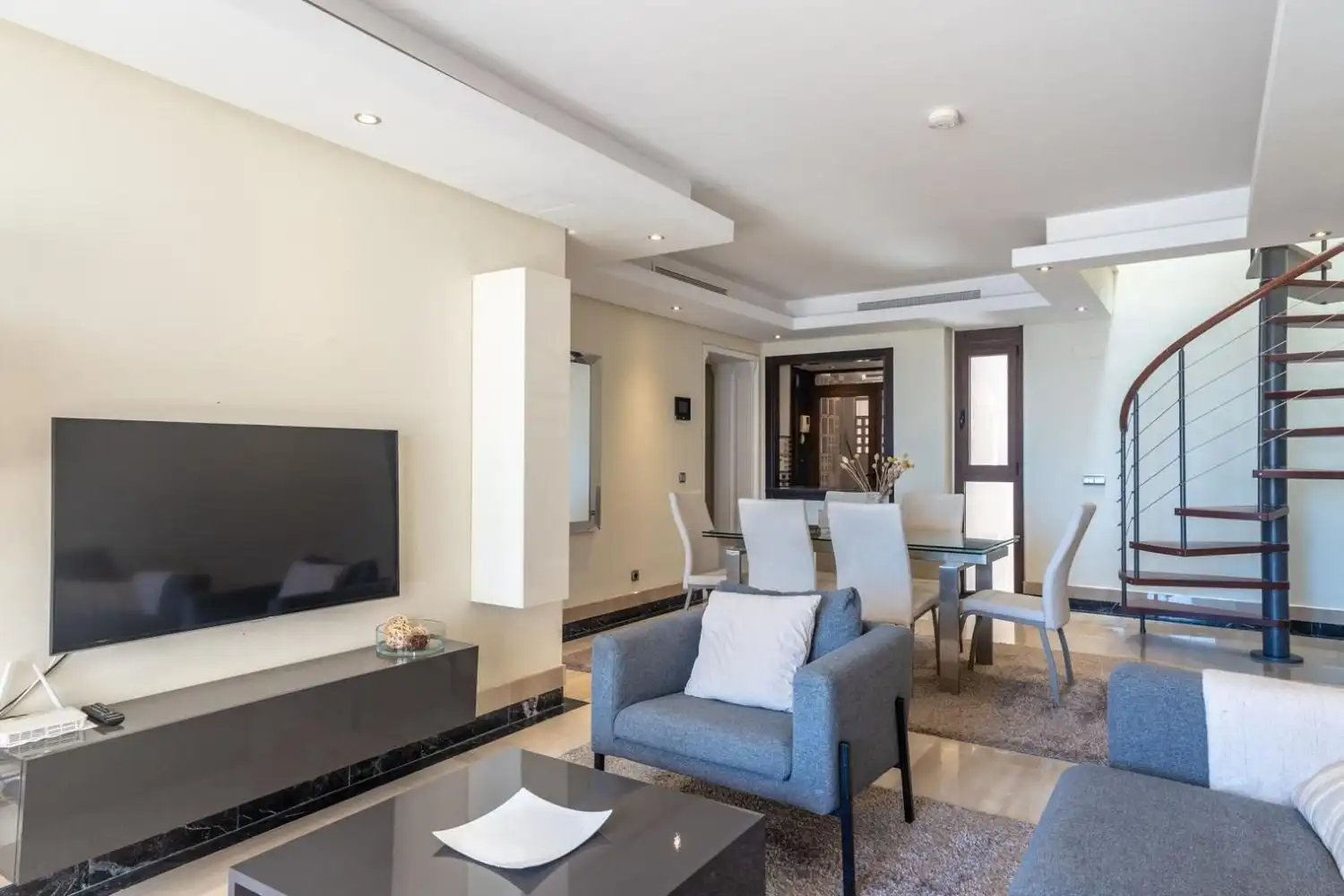 Modern beachfront duplex penthouse living room with stylish furniture and sea views.