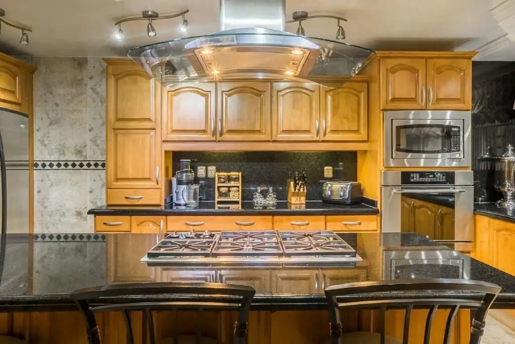 Spacious kitchen in a luxury Mexico City apartment with wooden cabinets and modern appliances.