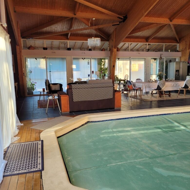 Indoor pool and bright living space in a luxurious home.