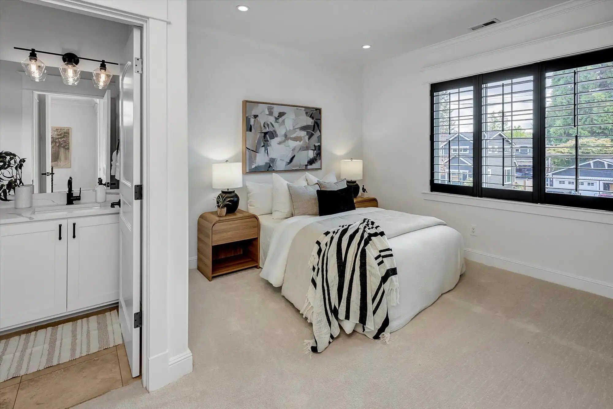 Elegant bedroom with modern decor and large windows overlooking the lake.