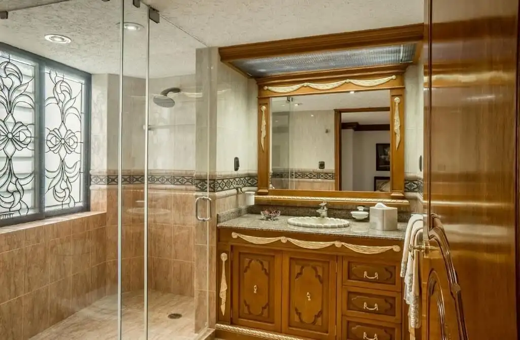 Luxury apartment bathroom with elegant wooden vanity and large mirror in Mexico City.