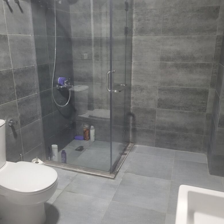Modern bathroom in a 2-bed apartment at Imperial Resort Hurghada with sleek gray tiles and glass sho.