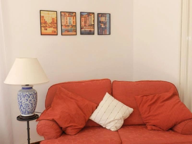 Villa Interior with Sofa and Wall Art in Arles-sur-Tech Villa interior featuring a red sofa, white pillow, and framed artwork on the wall in Arles-sur-Tech.