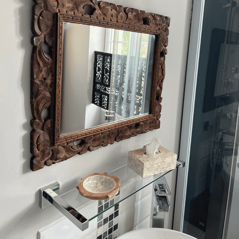 Elegant interior mirror with decorative wooden frame in a luxurious estate setting.