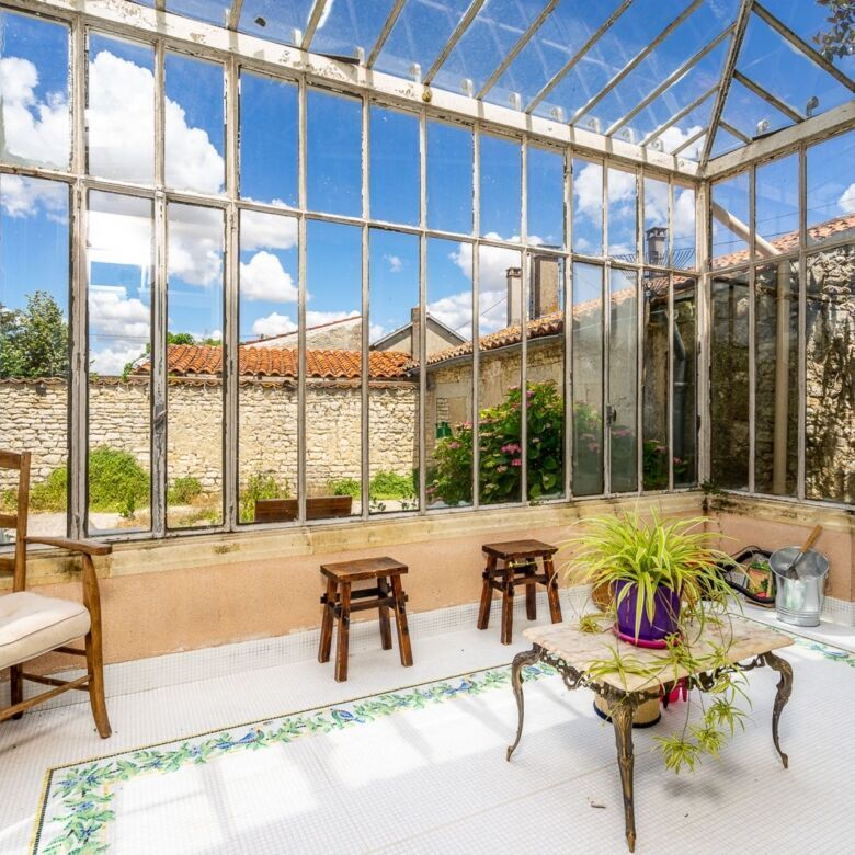 Bright sunroom overlooking lush garden and neighboring houses.
