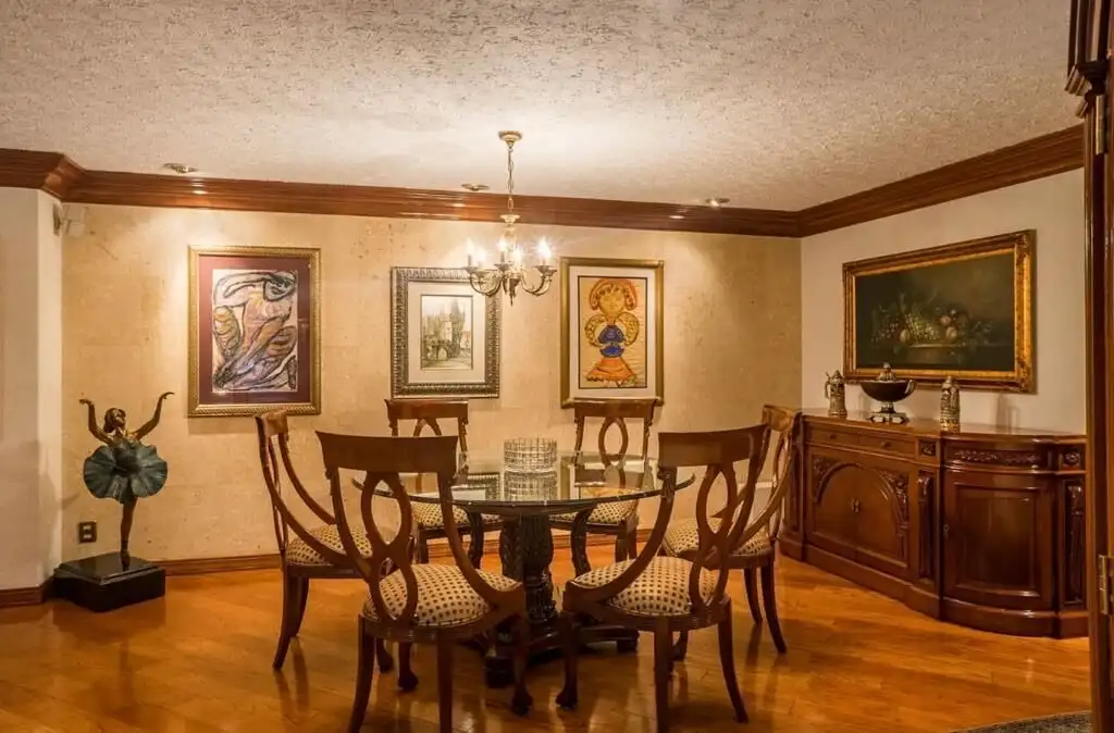 Elegant dining room in a luxury Mexico City apartment with classic wooden furniture and artwork.