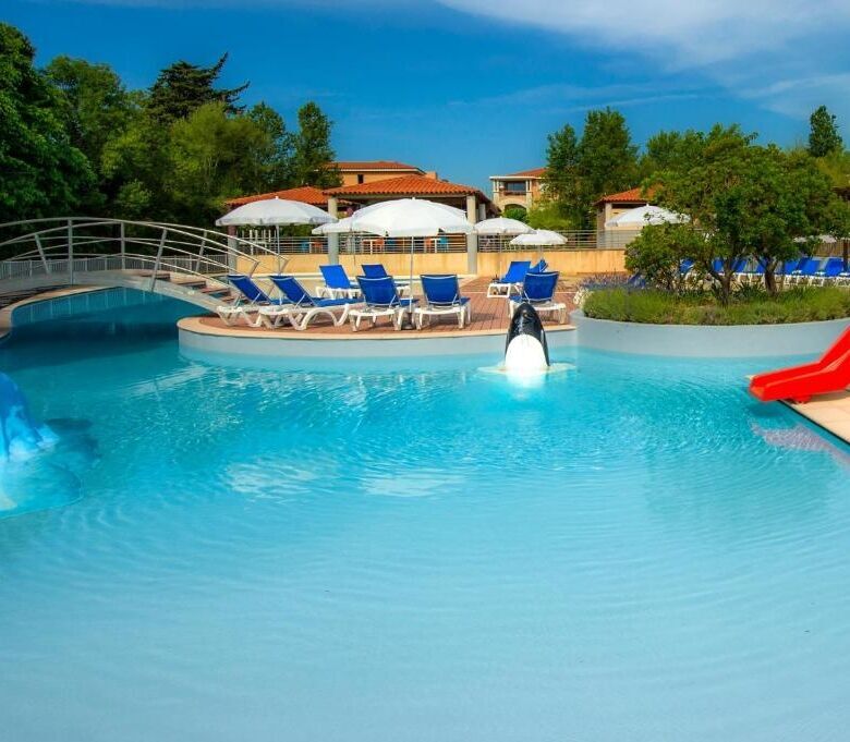 Pool with water slide and lounge chairs at a sunny resort in Mandelieu La Napoule.