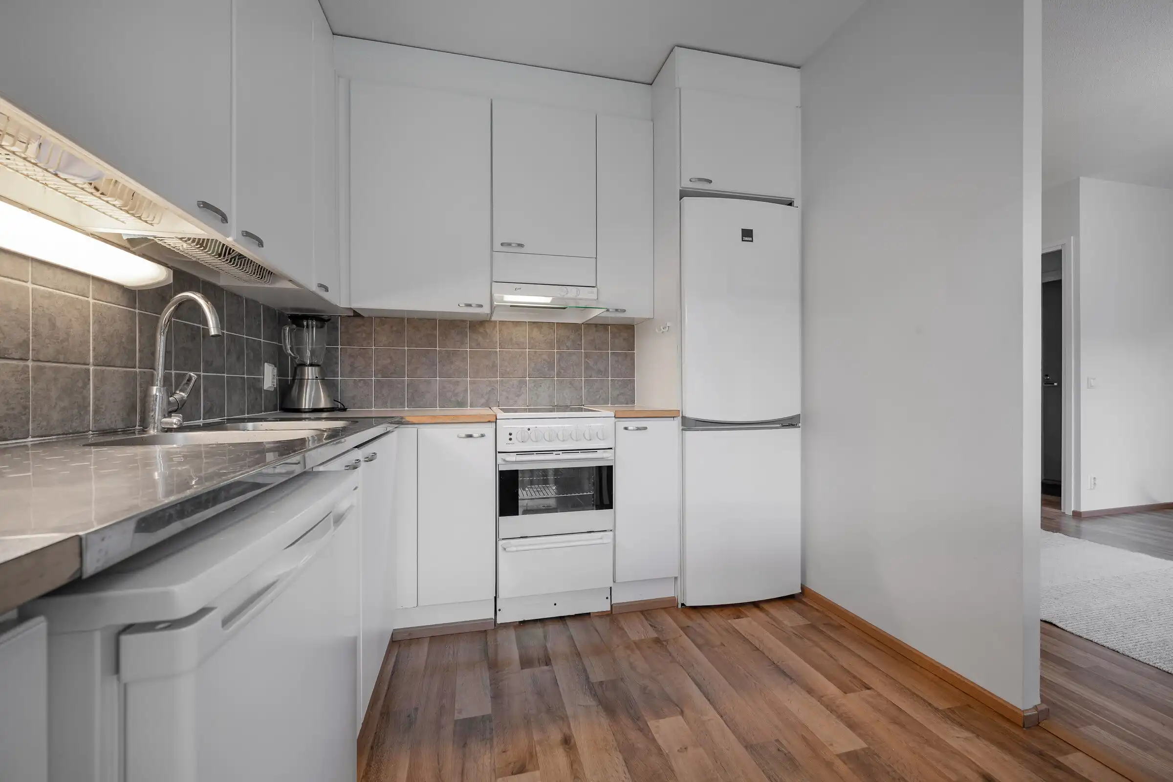 Modern white kitchen with appliances in Hirvensalo Turku, perfect for a cozy home.