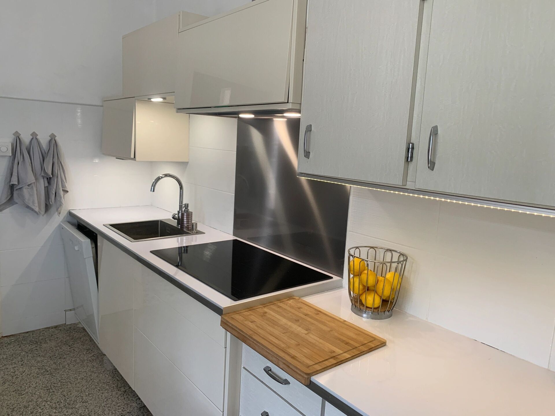 Modern kitchen with white cabinets and black countertop in Arles-sur-Tech.