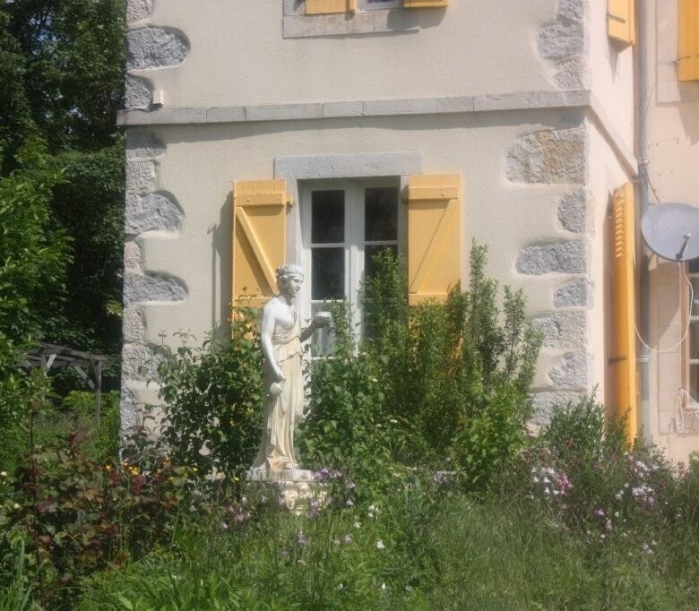 Chateau de Montcru with charming yellow shutters and lush garden in Allières Ariège.