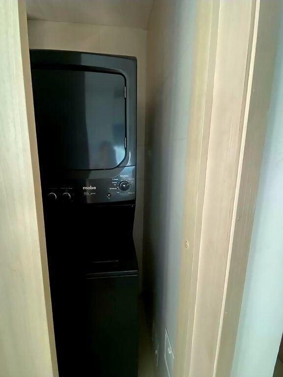 Compact laundry area with stacked washer and dryer in a modern penthouse.
