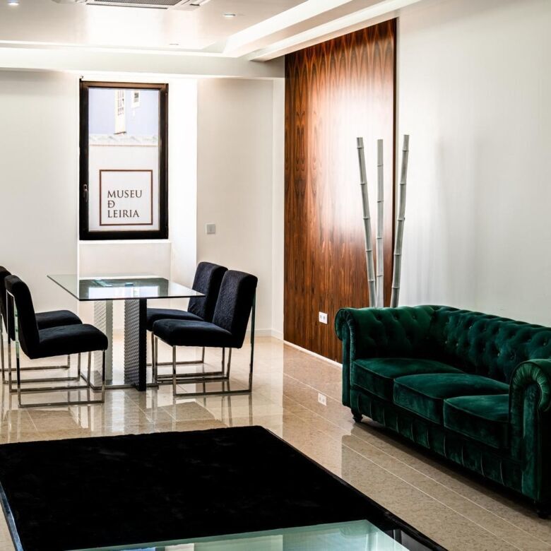 Boutique hotel lounge with elegant green velvet sofa and modern decor in Leiria. Perfect for investo.