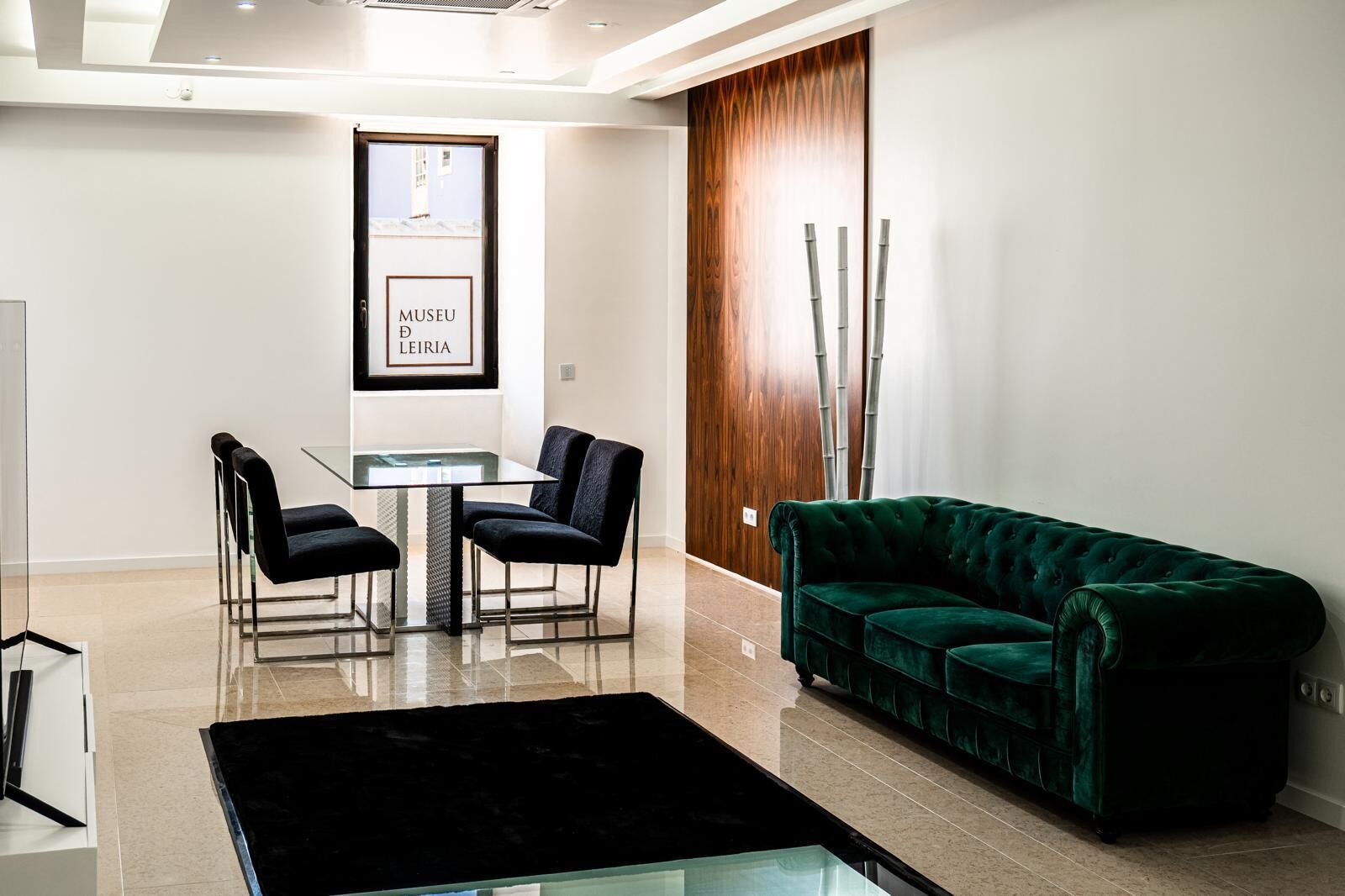 Boutique hotel lounge with elegant green velvet sofa and modern decor in Leiria. Perfect for investo.