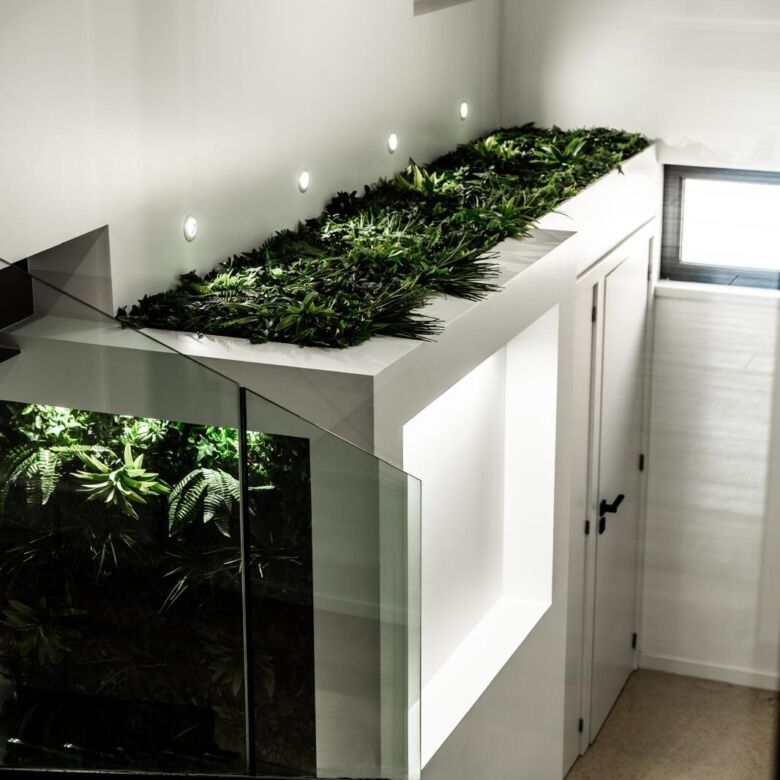 Indoor garden with vibrant plants on a white cabinet in a contemporary living space.