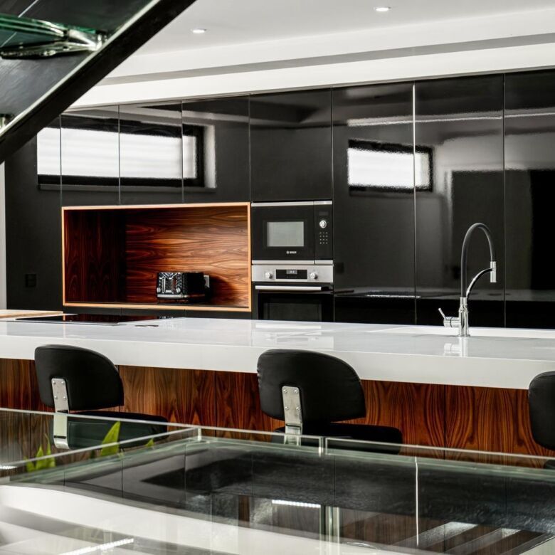 Modern kitchen with black cabinetry, white countertops, and sleek appliances in a boutique hotel.