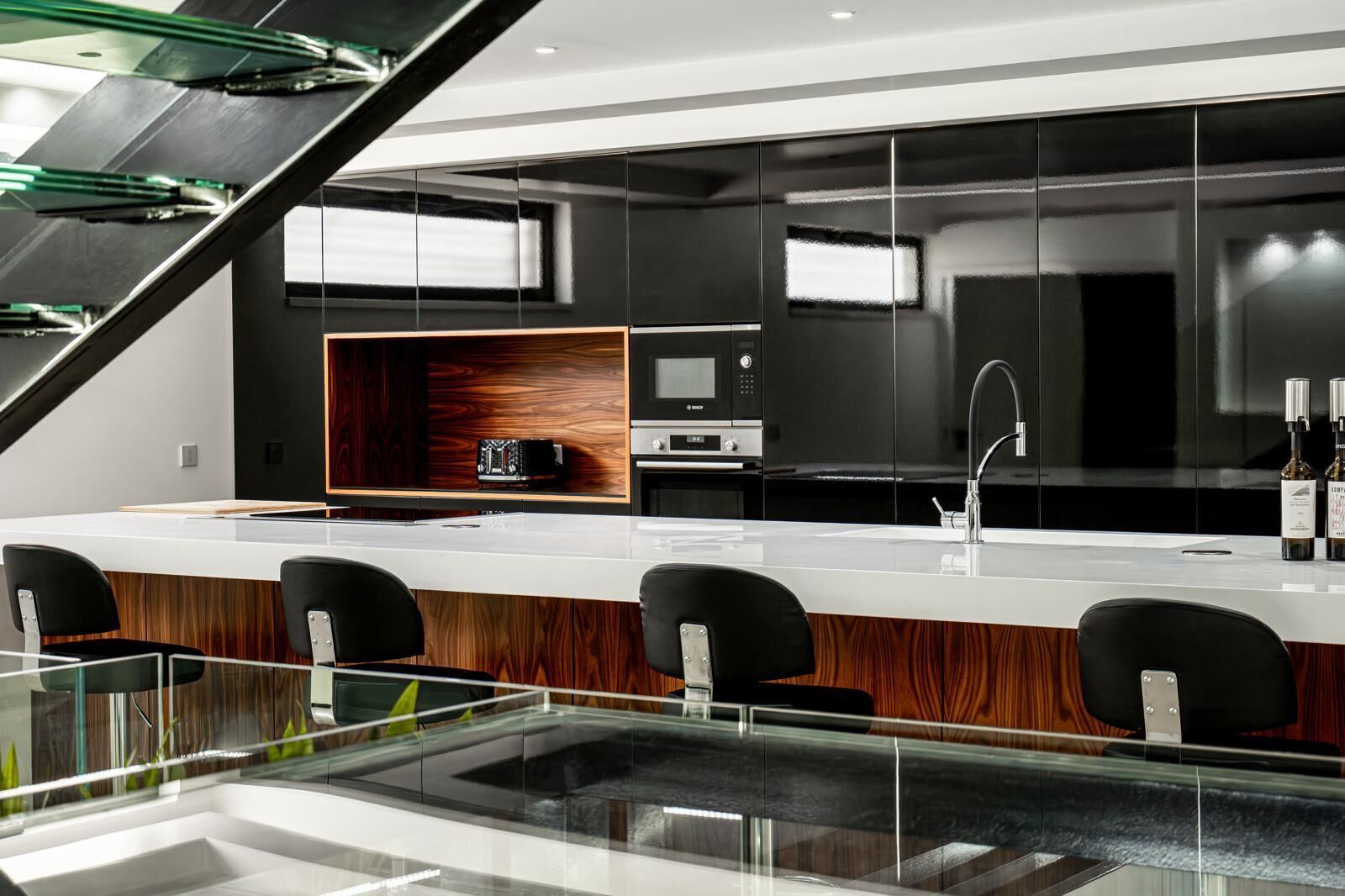 Modern kitchen with black cabinetry, white countertops, and sleek appliances in a boutique hotel.