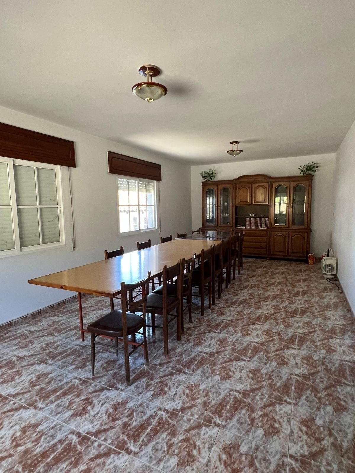 Bright and airy dining area with a large wooden table and chairs in a charming Taboada Galicia home.