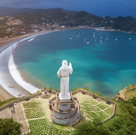 Beautiful coastal landscape of San Juan Del Sur with a statue overlooking the bay.