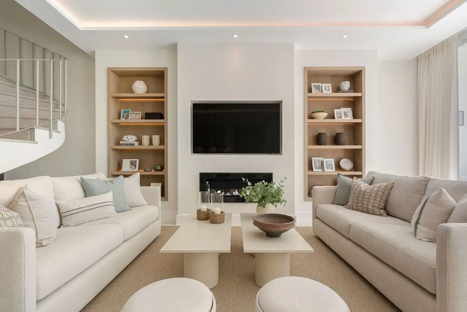 Stylish living room featuring a contemporary design with beige sofas and decorative shelves.