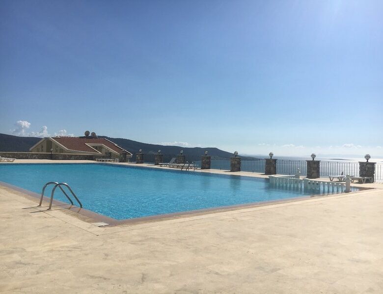 Poolside view of the luxurious 3-bed duplex apartment at Pearl Rock Retreat, Akbuk Didim, with stunn.