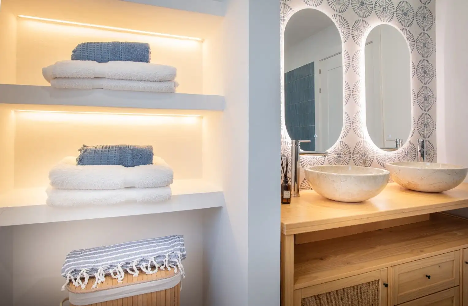 Bright bathroom featuring double vessel sinks, decorative mirrors, and contemporary design elements.