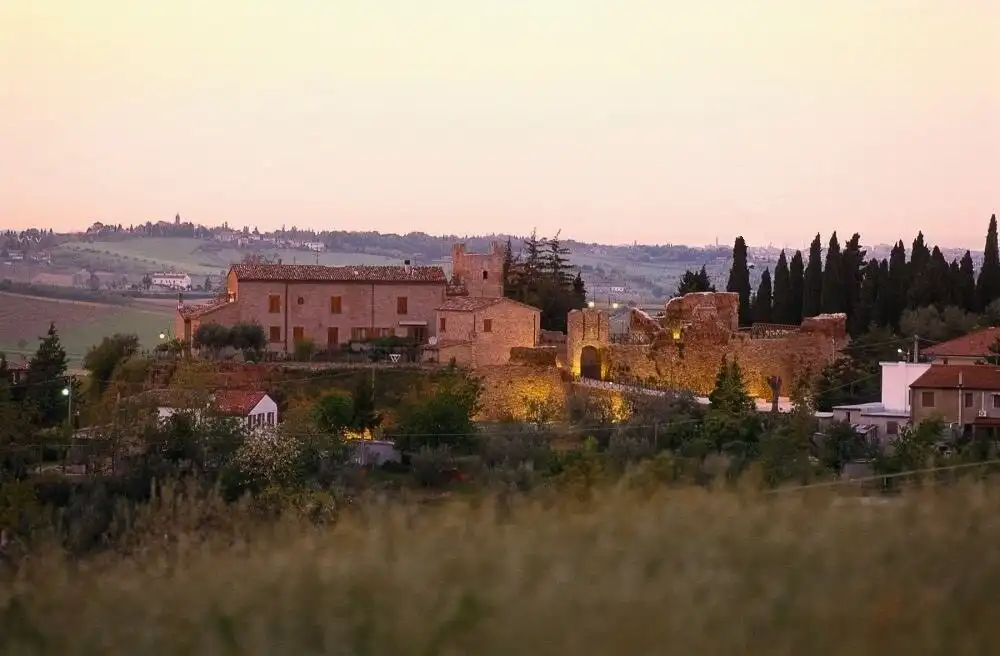 Castle in Coriano Rimini with scenic landscape views at dusk.