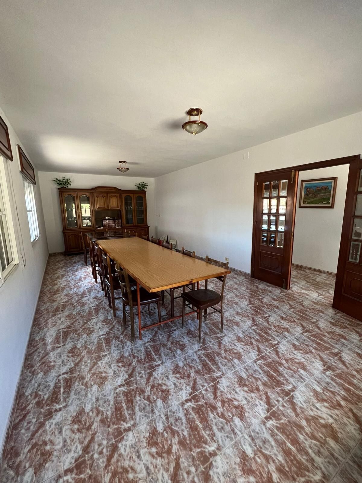 Bright dining area with large table and wooden chairs in a beautiful Taboada Galicia home.