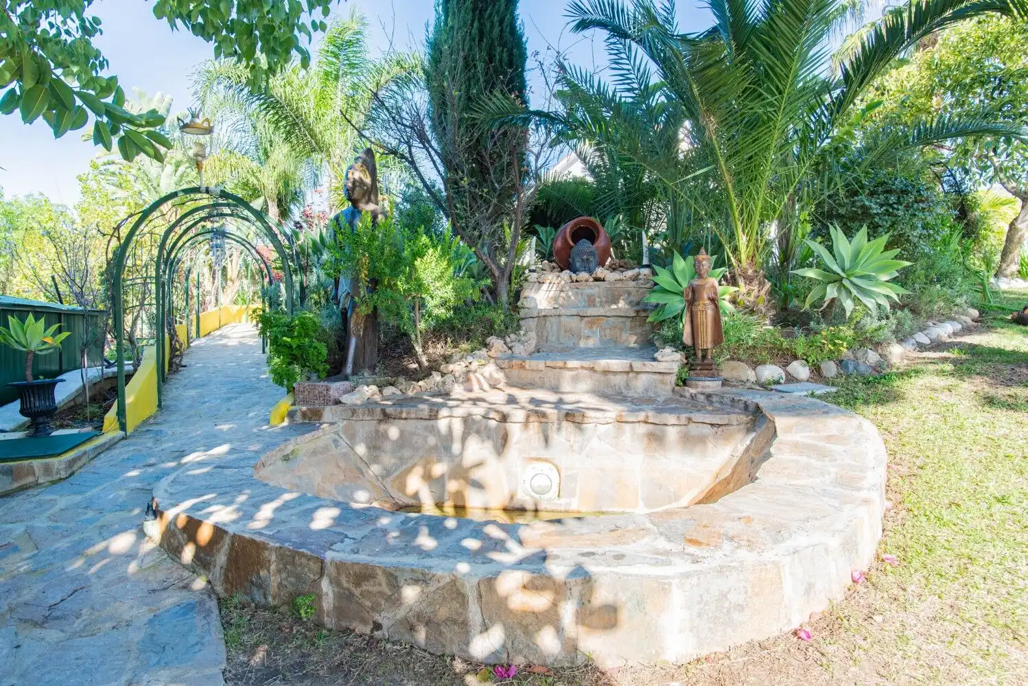 Traditional stone fountain in a lush garden setting in Los Llanos, Estepona.